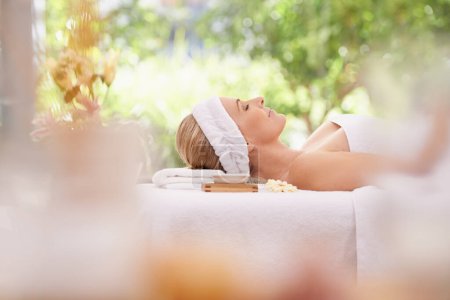 Photo for Lady, spa and rest for zen, peace and wellness with relaxation and calm. Woman, towel and massage table at resort, lounge or luxury parlor with rose for holistic body and skincare for detox and break. - Royalty Free Image