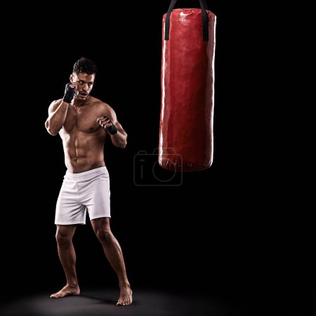 Photo for Ready, boxer and man with punching bag in studio with gloves for training with strength and muscle. Adult, athlete and male person in dark background, healthy and power with body, serious and sport. - Royalty Free Image