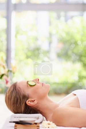 Photo for Woman, relax and sleeping with cucumber on towel at spa for facial treatment, care or peace at hotel or resort. Calm young female person in relaxation, zen or stress relief for beauty or skincare. - Royalty Free Image