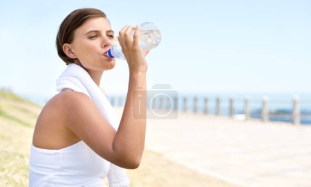 Photo for Woman, drink water and outdoor at beach for health, fresh air and fitness in nature, h2o and sea. Nutrition, detox and mineral liquid for thirst, hydration and exercise with beverage for wellness. - Royalty Free Image