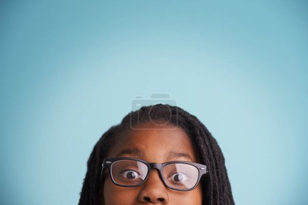 Foto de Visión, gafas o niño negro con ojos wow en estudio para el cuidado visual, bienestar u optometría sobre fondo azul. Marco, maqueta o cara de modelo masculino adolescente con pruebas de vista, prescripción u oftalmología. - Imagen libre de derechos