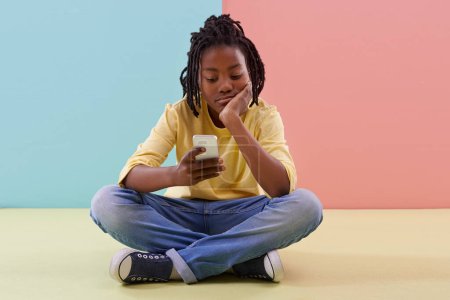 Photo for Phone, search and bored boy child on a floor with social media, reading or ebook in his home. Smartphone, lazy or African teen with app for Netflix and chill sign up, google ir or watching video. - Royalty Free Image