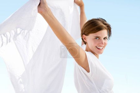 Photo for Freedom, portrait and woman with fabric in wind outdoor on vacation or holiday in summer with happiness. Cloth, material and girl relax with silk in air with blue sky in background with wellness. - Royalty Free Image
