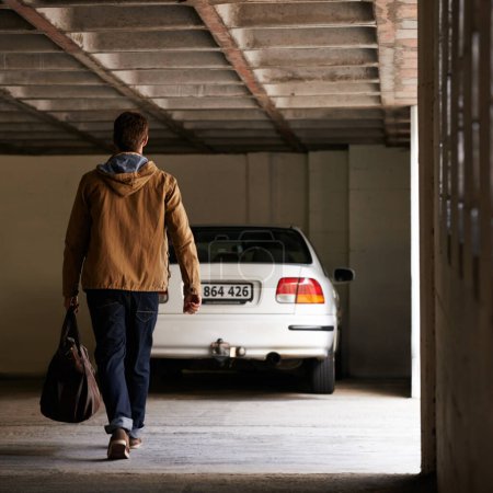 Photo for Parking, garage and man travel in car for morning commute or transportation for vacation on holiday. Luggage, bag and person with motor journey to work or walking in underground lot to parked vehicle. - Royalty Free Image