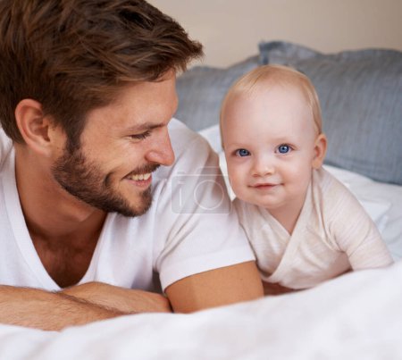 Photo for Happy, sweet and baby with father on bed relaxing, playing and bonding together at home. Smile, love and young dad laying with girl child, infant or kid in bedroom or nursery at family house - Royalty Free Image