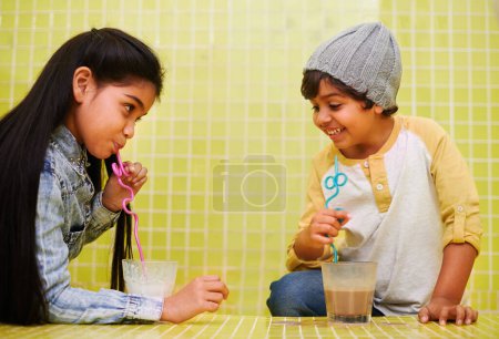 Photo for Children, fun and siblings on a floor with milk, chocolate or smoothie games, challenge or drinking competition at home. Love, family and children bonding with liquid contest in house with milkshake. - Royalty Free Image