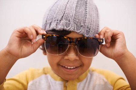 Photo for Child, portrait and sunglasses with smile and confidence with kid in a home. Happy, eyewear and youth fashion with an hipster boy with modern and casual style in a house with confidence and frames. - Royalty Free Image