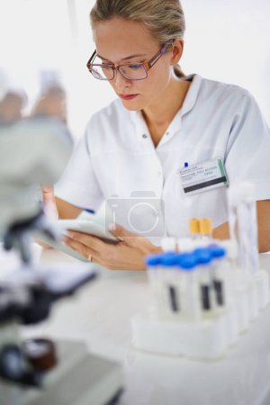 Photo for Medical, research and woman reading with tablet in laboratory with development in biotechnology. Doctor, typing or check results online of pharmaceutical report or review of innovation in science. - Royalty Free Image