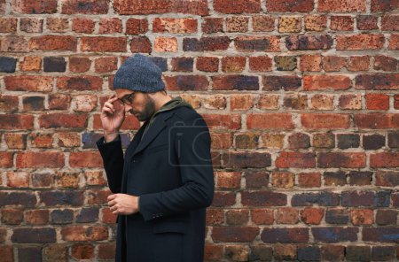 Photo for Fashion, man and thinking on brick wall with glasses for trendy, cool and style for urban with idea. Male person, outdoor and planning for weekend or holiday with winter outfit and stylish in Germany. - Royalty Free Image