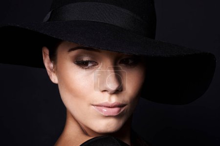 Photo for Woman, fashion and hat with mystery beauty on black background with makeup cosmetics, confidence or style. Female person, studio and model with mockup space in America with glamour, vintage or luxury. - Royalty Free Image