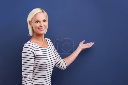 Photo for Woman, portrait and palm for advertising mockup space for discount information, promotion or announcement. Female person, face and hand gesture on blue background in studio or sale, choice or advice. - Royalty Free Image