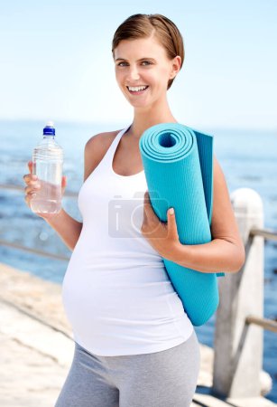 Téléchargez les photos : Femme enceinte, eau et yoga en plein air à la plage avec santé prénatale, fitness dans la nature avec h2o et océan. Nutrition, pilates grossesse et liquide pour maman, hydratation et tapis d'exercice avec bien-être. - en image libre de droit
