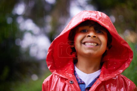 Photo for Rain, coat and portrait of boy in a forest for adventure, freedom or exploring games in nature. Winter, travel and face of excited kid in India outdoor for learning, journey or freedom in a storm. - Royalty Free Image