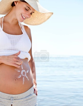 Photo for Pregnant woman, mom and sun drawing on belly with sunscreen, protection and summer at beach. Sea, travel and happy mother, health and wellness with skincare, vacation and sunblock for moisturizer. - Royalty Free Image
