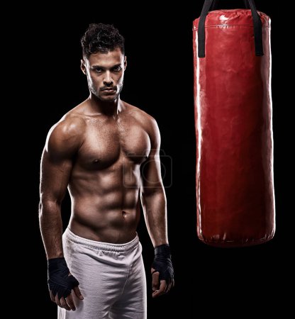 Photo for Serious, boxer and portrait of man, punching bag and gloves for training with strength and muscle. Adult, athlete and male person in dark background, healthy and power with body, sport and studio. - Royalty Free Image