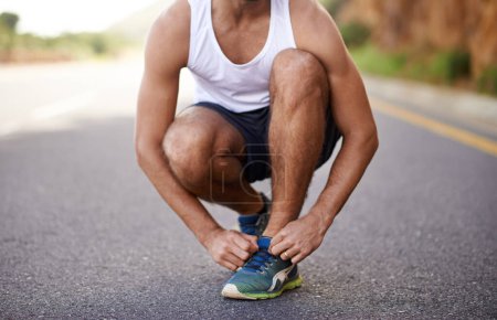 Photo for Man, feet and tying laces on road for running, prepare and shoes for cardio or training for marathon. Male person, legs and fitness on mountain street for performance, athlete and ready for exercise. - Royalty Free Image