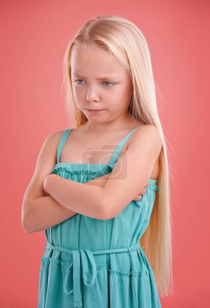 Photo for Frustrated, angry and girl with expression for sad, bad mood and unhappy in childhood isolated in studio background. Female child, gen z kid and arms crossed for tantrum, disappointment and serious. - Royalty Free Image
