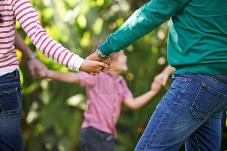 Famille, tenant la main et les enfants dansent dans le jardin ou jouent au jeu en été ensemble dans un cercle au parc. Sonnez un rosé, rond et les enfants en plein air en vacances, vacances et liens avec les parents dans la nature.