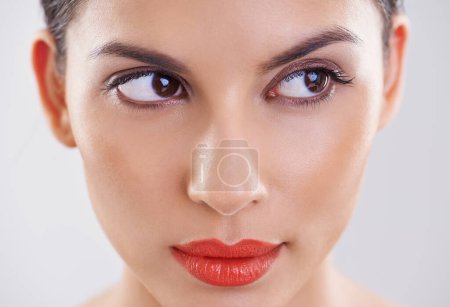 Woman, beauty and thinking in studio of makeup, dermatology and skin care on a white background. Closeup and face of a young model or person with facial foundation and inspiration or cosmetics ideas.