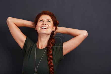 Téléchargez les photos : Femme heureuse, cheveux roux et rire en studio avec positivité, excité et sans soins isolé sur fond gris. Modèle rousse, éclat de joie et d'expression faciale, bonne humeur avec sourire et émotion. - en image libre de droit