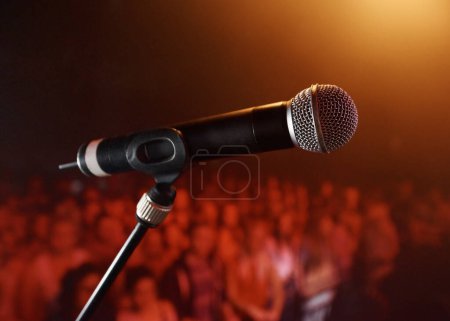 Foto de Sube al escenario... un micrófono de pie en un escenario con una multitud en el fondo - Imagen libre de derechos