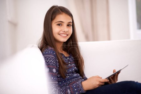 Photo for Portrait, home or kid with tablet for streaming, playing games or watching fun videos on movie website. Social media, online or happy girl with smile or technology to download on app or ebook on sofa. - Royalty Free Image