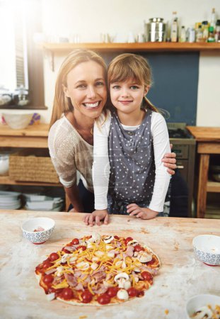 Foto de Mujer, niña y niña cocinando pizza con sonrisa en retrato con abrazo en cocina para aprender, ayudar y desarrollar. Alimentación, madre e hija con masa, enseñanza y feliz por la vinculación en el hogar familiar. - Imagen libre de derechos