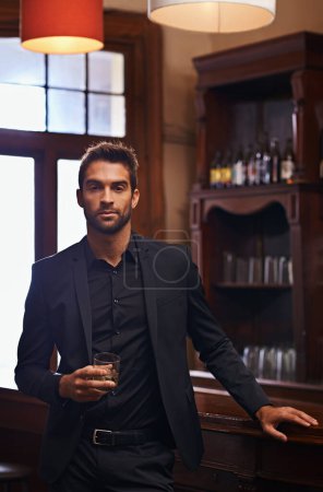 Photo for Young Businessman, portrait and alcohol for break in hotel and drink to relax on corporate trip. Entrepreneur, pub and confident face by glass of whisky for leisure and professional for work travel. - Royalty Free Image