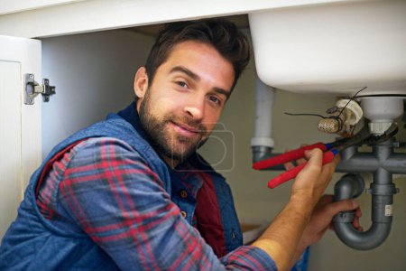 Photo for Man, portrait and plumber with wrench for pipe repair, service or fix in home maintenance or indoor leak. Male person or handyman smile with water damage or sink of plumbing professional at the house. - Royalty Free Image