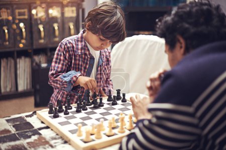 Photo for Child, father and playing chess game for challenge competition or moving piece, learning or planning. Son, parent and checkmate choice with king or queen for bonding or night, pawn or problem solving. - Royalty Free Image
