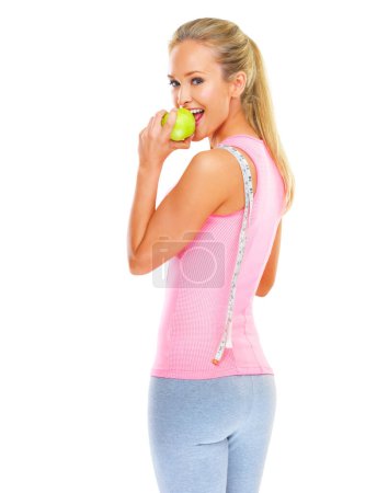 Photo for Apple, measuring tape and happy woman in portrait for fitness in studio, health and wellness with nutrition. Girl, workout and exercise for self care with sports, fruit or snack on white background. - Royalty Free Image