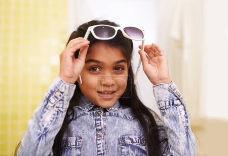 Photo for Girl, portrait and sunglasses for home, holiday and vacation with fashion and cool style. Happy face of a young Mexican kid or child with smile, casual and trendy accessory or shades for fun indoors. - Royalty Free Image