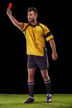 Photo for Sports, referee or man with a red card for warning, foul call or penalty review in football game on turf. Soccer match, discipline or male person with punishment, rules or caution on black background. - Royalty Free Image