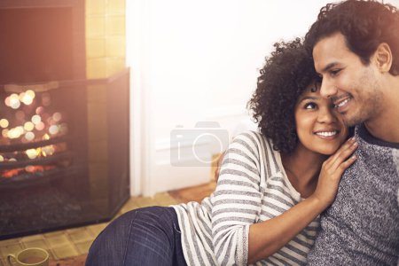 Photo for Couple, fireplace and relax in embrace, smile and peace or calm and proud of marriage or commitment. Happy people, holding and hugging on floor in home on weekend, support and trust in relationship. - Royalty Free Image