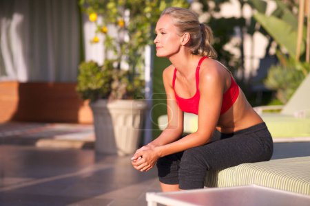 Photo for Woman, thinking and exercise outdoor on patio for health, wellness and memory in sportswear for workout at home. Relax, reflection for training or fitness with fresh air, sun and challenge with sport. - Royalty Free Image