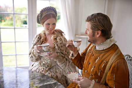 Photo for King, queen and couple with tea in castle, smile and conversation in vintage clothes with luxury at breakfast. Woman, man and drink together in morning with Victorian fashion at regal palace in UK. - Royalty Free Image