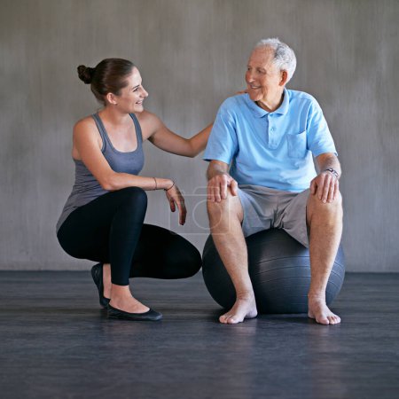 Photo for Exercise ball, consultation and physiotherapist with man for muscle exercise consultation at clinic. Physical therapy, happy and healthcare worker helping senior patient at rehabilitation center - Royalty Free Image