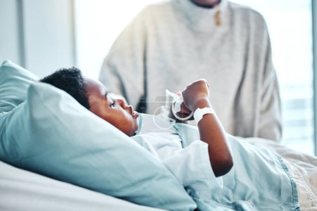 Foto de Médico, enfermo y niño en cama en el hospital para la recuperación de la cirugía, enfermedad o diagnóstico. Cuidado de la salud, curación y niño africano joven paciente que descansa para lesiones o tratamiento del virus en la clínica pediátrica - Imagen libre de derechos