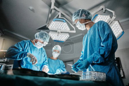 Photo for Surgeon group, procedure and operating room at hospital in scrubs, ppe and tools for healthcare emergency. Doctors, teamwork and together in icu, medical surgery and services for wellness at clinic. - Royalty Free Image