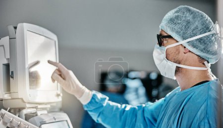 Photo for Doctor, scrubs and monitor with machine in theatre for surgery, cardiology analysis and information. Medical, man and digital technology in hospital for operation, procedure or healthcare examination. - Royalty Free Image