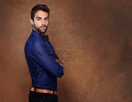 Photo for Fashion, portrait and business man in studio with arms crossed for confidence, serious or corporate on brown background. Entrepreneur, consultant and male person for formal, styling or trendy clothes. - Royalty Free Image