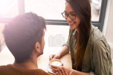 Photo for Couple, date and coffee shop with conversation, smile and talking together with hot drink in a cafe. Woman, social and happy from discussion and chat in a restaurant with tea or cappuccino at table. - Royalty Free Image