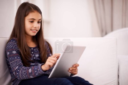 Photo for Relax, home or girl with tablet for elearning, playing games or streaming videos on a movie website. Education, online or female child with technology to download on app or reading ebook on couch. - Royalty Free Image