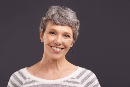 Photo for Portrait, smile and senior woman with retirement, happiness and casual outfit on grey studio background. Face, pensioner or elderly person with mockup space and cheerful with clothes, peace or joyful. - Royalty Free Image