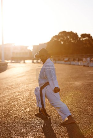 Photo for Man, martial arts and karate in street for portrait with fist, balance or warrior for battle in city. Person, contact sports and fight with power, conflict and self defence in road, outdoor or sunset. - Royalty Free Image