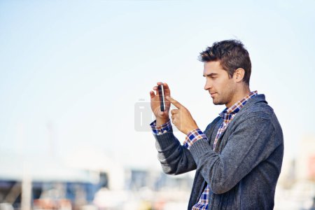 Photo for Man, phone and photography at harbor, outdoor and space for mockup with creativity on urban sidewalk. Person, photographer and smartphone for vacation, profile picture or memory on road in Cape Town. - Royalty Free Image