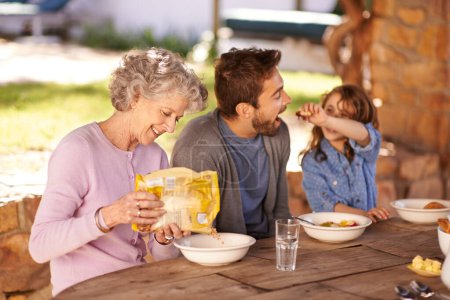 Photo for Happy family, food and breakfast in backyard of home for nutrition, bonding and eating together with porridge. Father, grandma and child with healthy diet, meal or feed at dining table in the morning. - Royalty Free Image