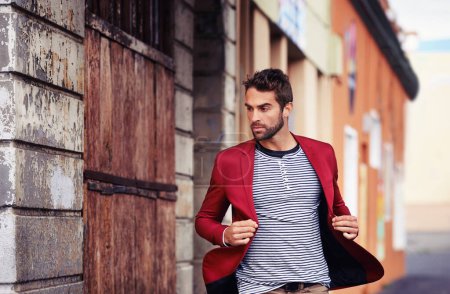 Photo for Man, think and fashion in urban outdoor with outfit for casual or smart wear on wall for trends and style. Confident, street and city in elegant clothes with blazer in downtown for classy look. - Royalty Free Image