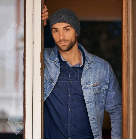 Photo for Man, portrait and winter fashion in house, window and hipster with serious male person standing in warm clothes. Beanie, head wear for comfort, indoor and cool denim jacket for manly trends in Canada. - Royalty Free Image