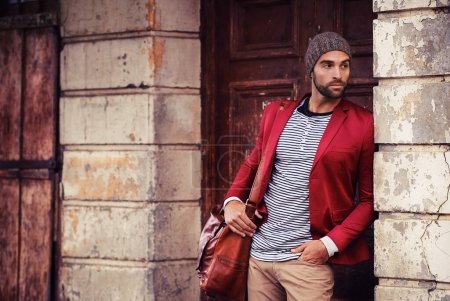 Photo for Man, fashion and model in city with confidence, trendy style or winter accessories with bag outdoor. Urban, unique and stylish with designer clothes, edgy and chic with wool hat or beanie for weather. - Royalty Free Image
